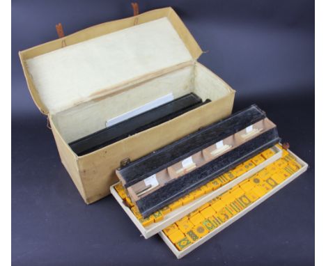 A 1930's Mahjong set, with two trays of resin counters and four ebonised stands enclosing brown stick counters, in canvas cas