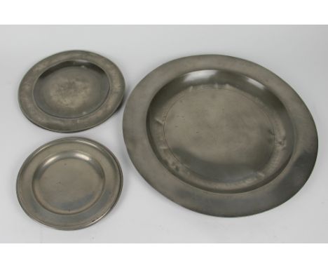 An 18th century pewter charger, with London touch marks, 38cm; four smaller pewter plates and an enamel bowl (6)