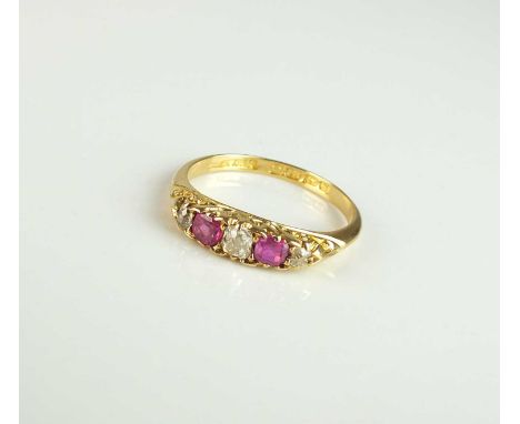 An Edwardian 18ct gold five stone diamond and untested ruby ring, the graduated stones claw set in yellow gold to yellow gold