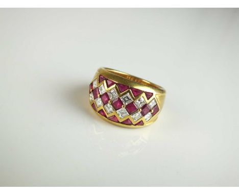 An 18ct gold ruby and diamond ring, designed as a central row of square cut rubies flanked to each side by a row of square cu