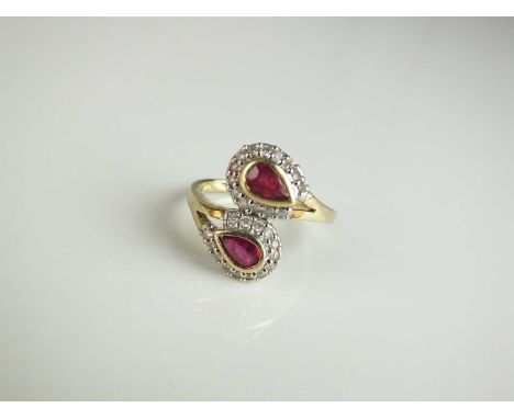 A 9ct gold ruby and diamond double pear cluster ring, of crossover design, size O 1/2, weight approx 3.8gCondition:Stones are