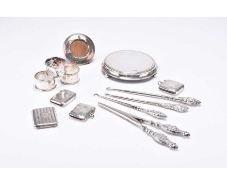 A small collection of silver, comprising; four silver vesta cases, three silver napkin rings, an Edwardian silver mounted tea