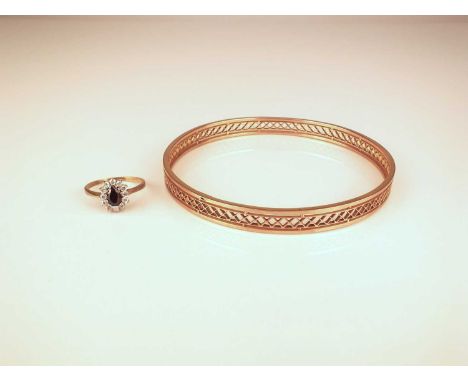 A yellow metal slave bangle with pierced decoration, stamped '9ct', inner diameter approx 82mm, together with a 9ct gold sapp