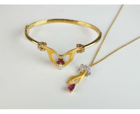 A Carrera y Carrera ruby and diamond bracelet and necklace, the bangle formed as two matt textured hands holding a cluster of