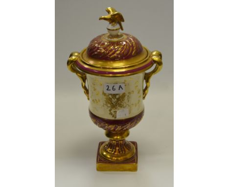 A Coalport two handled urn and cover, decorated with village cricket team within gilt cartouche, maroon ground picked out in 