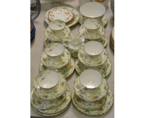 A hard paste tea service for twelve in tones of green, including cups and saucers, cream jug, side plates, etc 