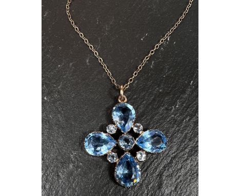 A pendant on a 9 carat gold chain, a cross formed from 4 tear drop shaped bright blue stones, interspersed with paler blue st