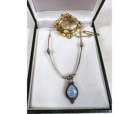 A pendant set with an opal coloured stone, stamped 925 on a cylindrical chain with circular beads; an Edwardian brooch set wi