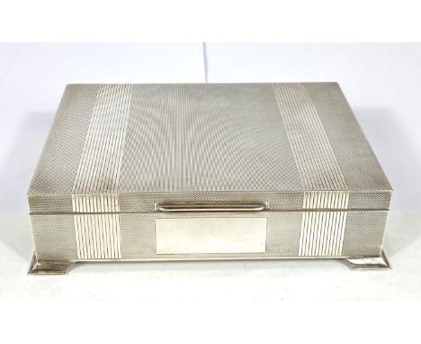 A hallmarked silver cigarette box, engine turned, on bracket feet, Birmingham 1961 