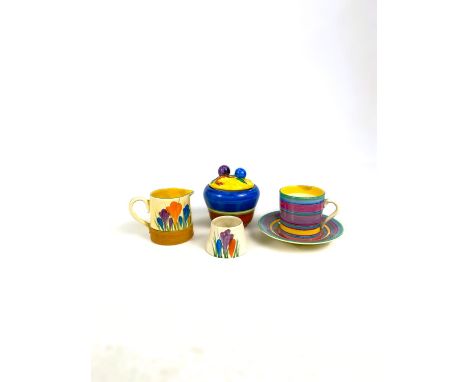 A Clarice Cliff crocus pattern cream jug and egg cup; a coffee can and saucer with concentric coloured lines; a similar musta