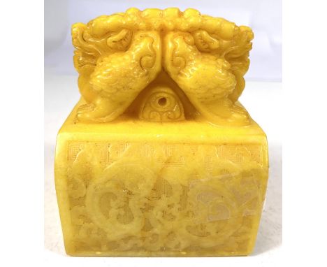 A large Chinese Republic period Imperial yellow heavily carved soapstone seal depicting mythical animal to top scrolling drag