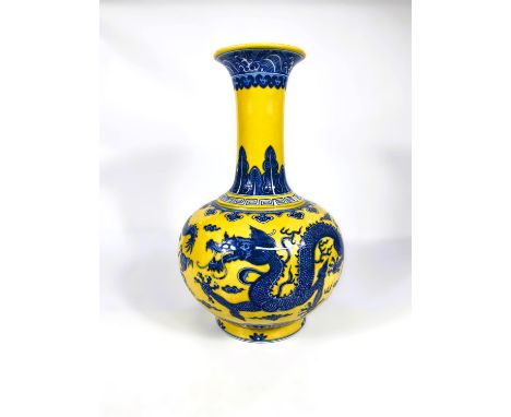A Chinese porcelain vase of globular form with elongated neck and everted rim, decorated in underglaze blue with dragons on y