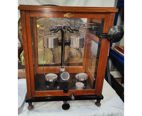 A cased hydrometer set; a set of scientific balances and weights. 