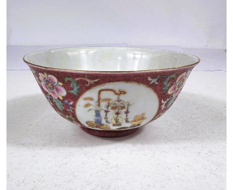 A Chinese bowl with pink ground, circular panels of vases and objects, seal mark to base, diameter 15cm 