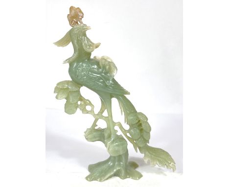 A Chinese jade coloured hardstone carving of bird on floral branch of tree, ht. 27cm 