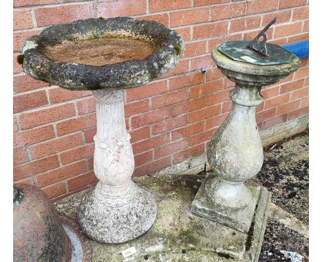 A stone garden sundial and a similar bird bath. 