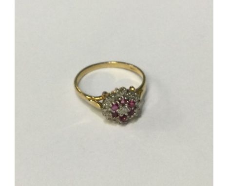 An attractive ruby and diamond daisy head cluster ring in 9 carat two colour setting. Approx. 2 grams. Est. £60 - £80.
