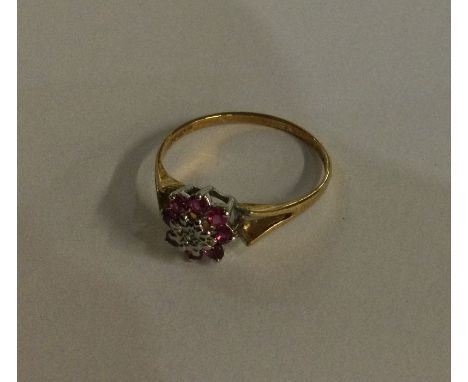 A small 9 carat ruby and diamond cluster ring in two colour gold. Approx. 2 grams. Est. £50 - £80.