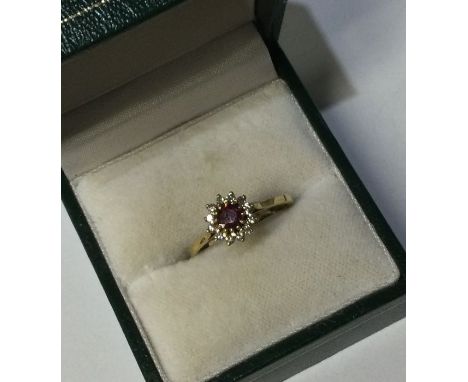 An 18 carat gold ruby and diamond cluster ring in claw mount. Approx. 2 grams. Est. £100 - £150.