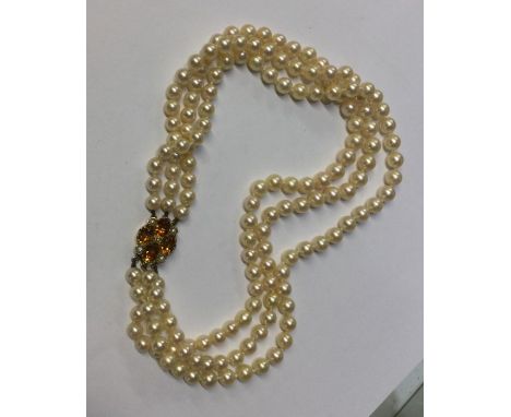 A heavy triple string of pearl beads with gold clasp. Approx. 56 grams. Est. £50 - £80.