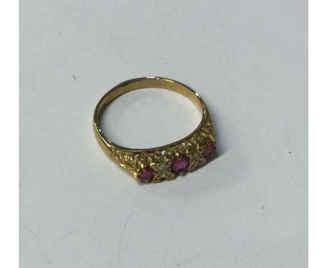 A ruby and diamond seven stone ring in carved 9 carat setting. Approx. 3 grams. Est. £50 - £80.