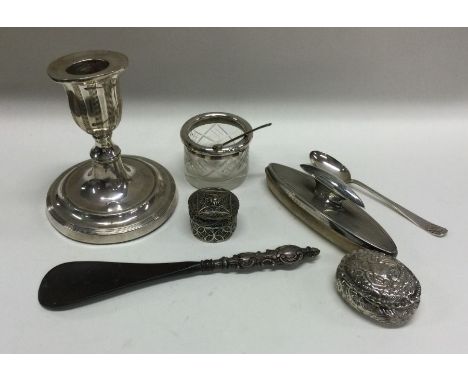 A box containing a silver nail buffer, candlestick, salt spoons etc. Est. £20 - £30.