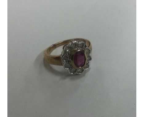 A large oval diamond and ruby cluster ring. Approx. 5 grams. Est. £200 - £300.