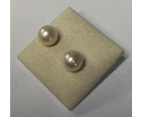 A pair of pearl and gold ear studs. Approx. 4 grams. Est. £40 - £60.