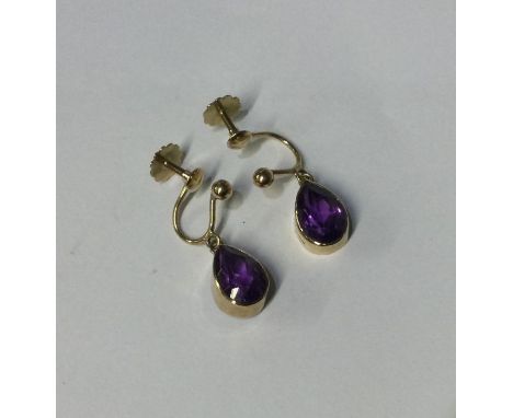A pair of amethyst tear shaped earrings in gold mounts. Approx. 2 grams. Est. £50 - £80.