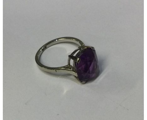 An amethyst single stone ring in white gold claw mount. Approx. 5 grams. Est. £50 - £80.