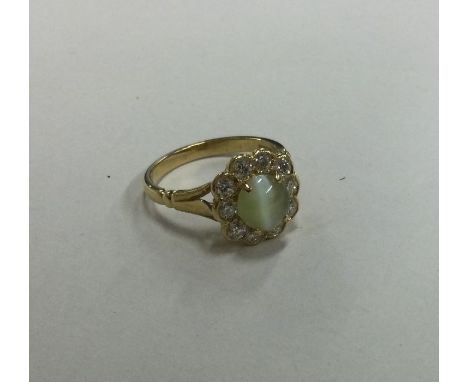 A good 18 carat gold mounted cat's eye and diamond daisy head cluster ring. Approx. 8 grams. Est. £600 - £800.
