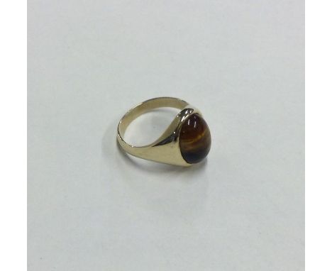 A 9 carat mounted tiger's eye gypsy set ring. Approx. 4 grams. Est. £60 - £80.