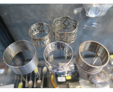 A collection of three silver napkin rings and two silver plated napkin rings, together with six cased Art Deco silver coffee 
