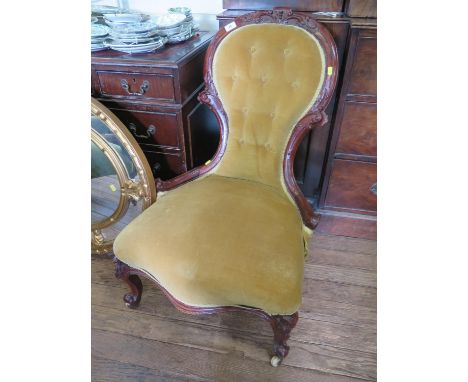 A pair of mid Victorian lady's and gentleman's salon chairs, carved with scrolls, the button spoon backs on foliate carved ca