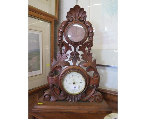 A Victorian walnut table top barometer and timepiece, the foliate scroll and husk carved frame enclosing a timepiece with the