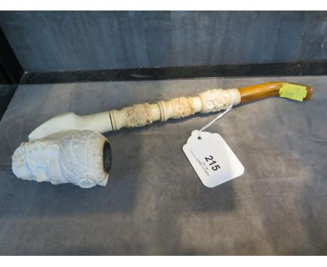 A Meerschaum pipe, in the form of a bearded Turk, with floral carved stem and amber mouthpiece, 26 cm long 