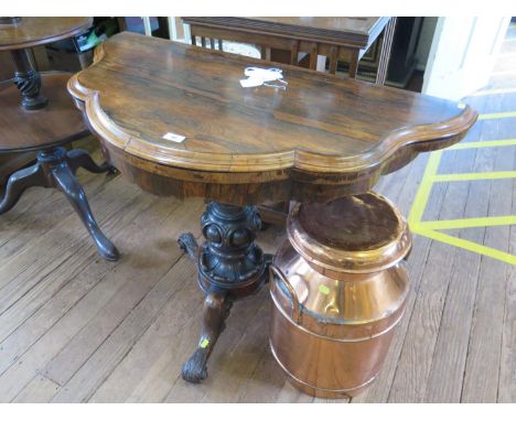 A mid Victorian rosewood foldover card table, the shaped top and frieze over a cabochon carved tapering stem on three cabriol