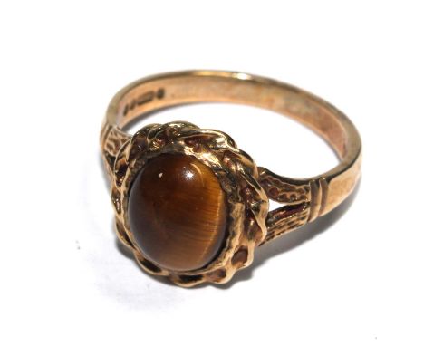 A 9 carat gold ring set with a cabochon tigers eye 