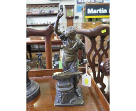 After E. Saalmann, a bronze of a blacksmith at his anvil, signed on the base, 32 cm high 