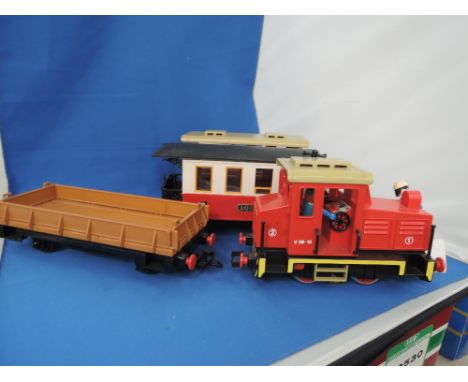 A Playmobile G scale 0-4-0 engine and flat wagon and two LGB G scale carriages