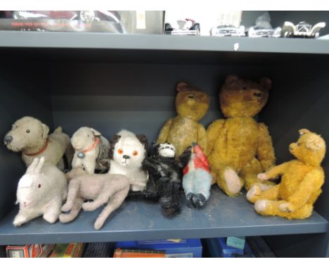 A shelf of mid 20th century straw filled soft animals and teddy bears including dogs, rabbit, Felix the Cat etc