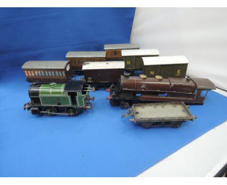 A selection of Hornby and Bassett Lowke O gauge including clockwork 0-4-0 LNER tank engine, three carriages, three vans and a