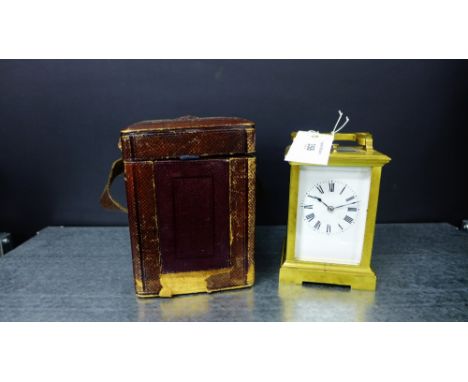 A 19th century brass cased carriage clock, the circular enamel dial with Roman numerals, complete with key and leather carryi