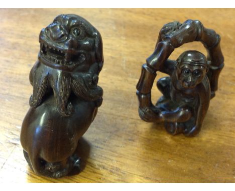 A carved hardwood netsuke depicting monkey within bamboo ring with inlaid bead eyes - mother-of-pearl seal mark; and another 