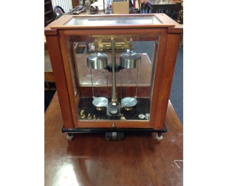 A set of Stanton laboratory scales, model A.D.I in a stained glazed case, raised on adjustable feet, the balance on polished 