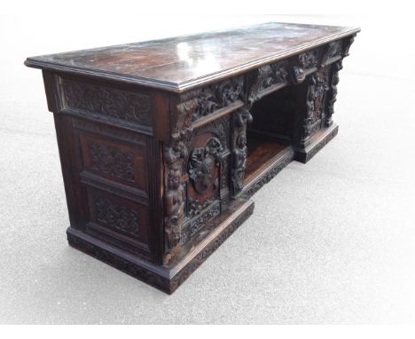 A large Victorian carved oak sideboard, probably by Gerrard Robinson, having rectangular moulded top above three foliate acan