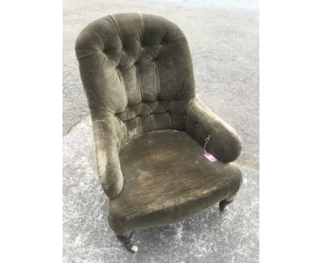 A Victorian button upholstered armchair with spoon back above sprung seat raised on turned mahogany legs with brass cappings 