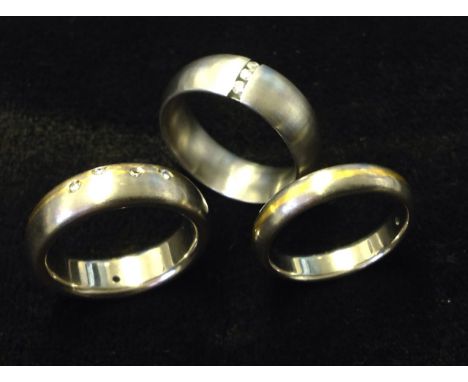 Three contemporary titanium & diamond mounted wedding rings. (3)