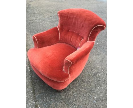 A Victorian tub armchair, with button upholstered back above a rounded sprung seat, supported on turned mahogany legs with br