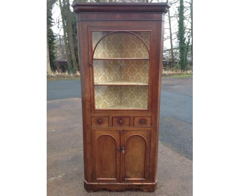 A nineteenth century oak corner cupboard, with cushion moulded cornice above arched astragal glazed door enclosing shelves, h
